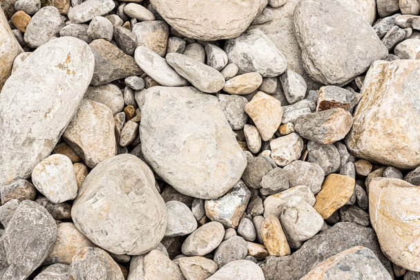 Backdrop of different size gray pebbles on beach - Foto, imagen