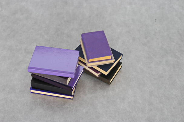 Empilement de livres violets sur fond gris - Photo, image