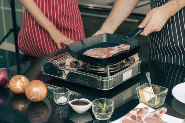 Close-up shot of couple cooking a steak on the stovetop. - Photo, Image