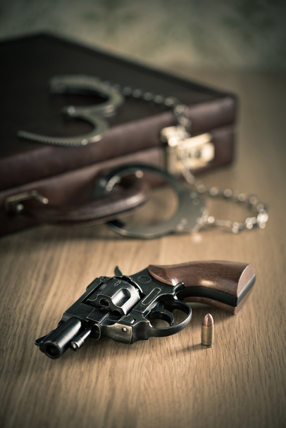 Revolver and bullet with briefcase - Фото, зображення