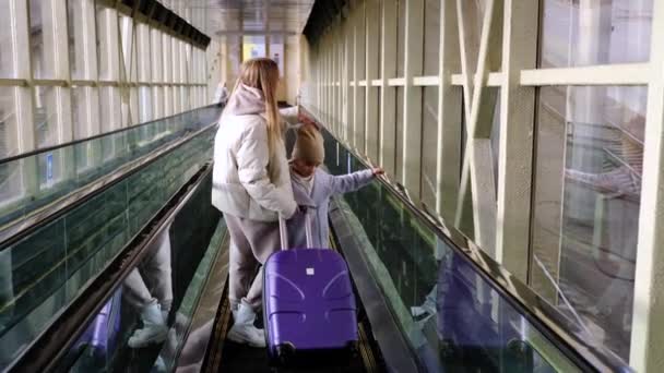  Mom and daughter go down the escalator from the station building to the platform - Footage, Video