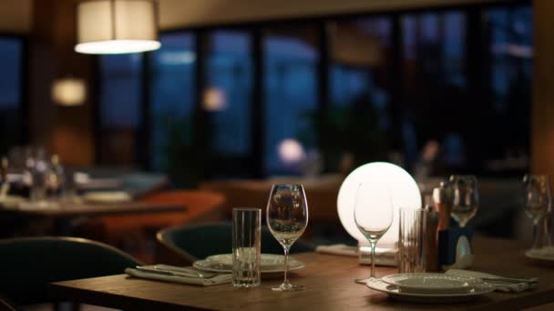 Μοντέρνο τραπέζι εστιατόριο του ξενοδοχείου στο καφέ το βράδυ. Γυναίκα περιμένει ρομαντικό δείπνο - Πλάνα, βίντεο