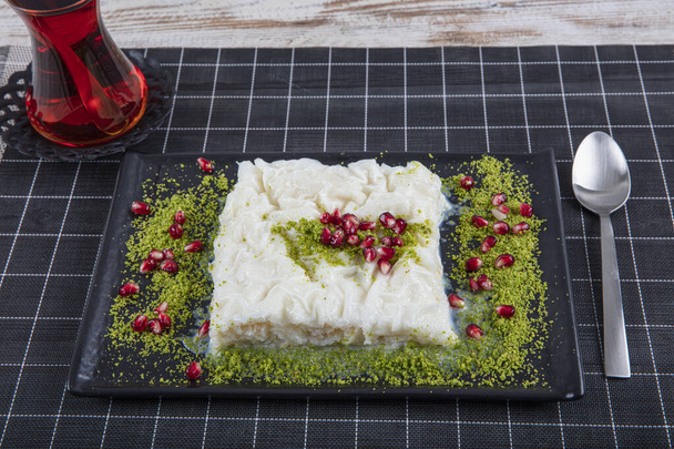 Turco Tradicional Ramadã Sobremesa Gullac na mesa. É feito com gullac, leite, água de rosas, noz, baunilha. É decorado com romã e pistache. Sobremesa de cozinha otomana - Foto, Imagem