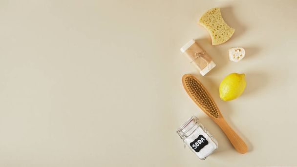 soap, luffa, soda can, lemon, wooden brush and sponge on beige background copy space, eco cleaning concept, use of non-toxic detergents in house cleaning - Fotó, kép