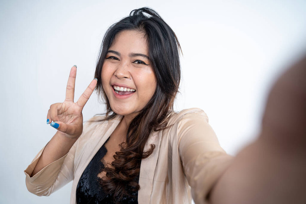 young woman selfie using mobile phone camera with v sign - Foto, afbeelding