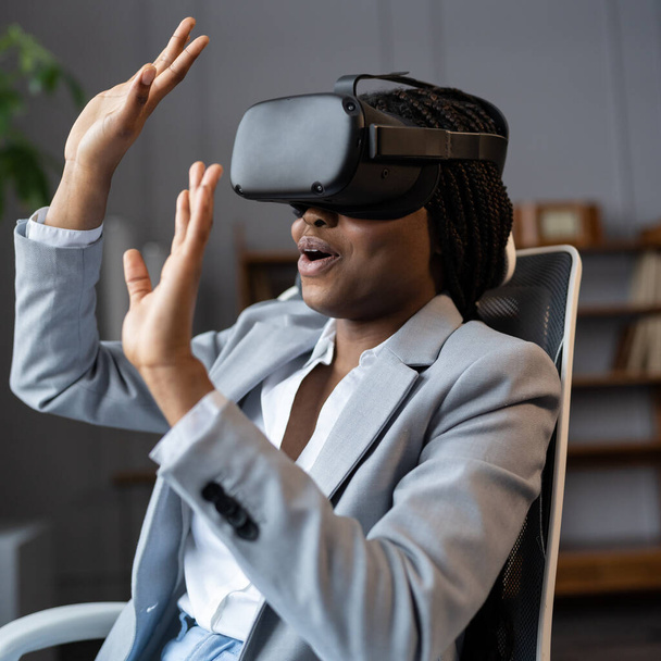 Geschockt von VR schwarze Geschäftsfrau in Virtual-Reality-Brille sehen 360-Grad-Video am Arbeitsplatz - Foto, Bild