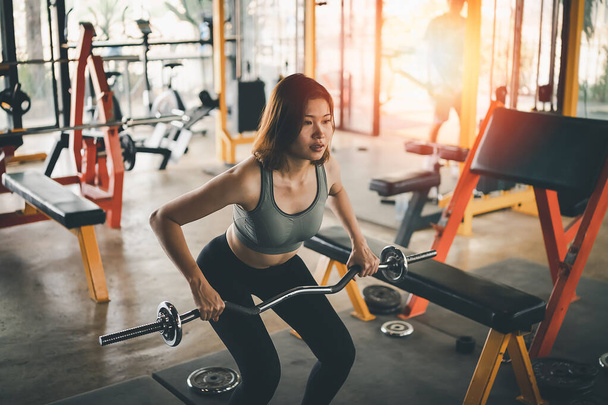 mujeres deporte feliz ejercicio peso pesas pesas entrenamiento en el gimnasio. atleta chica entrenamiento fuerte y buena salud y fuerza - Foto, imagen