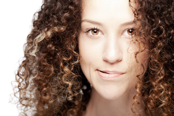 Beautiful brunette girl with long curly hair. Closeup studio portrait. Serious face expression. - Fotografie, Obrázek