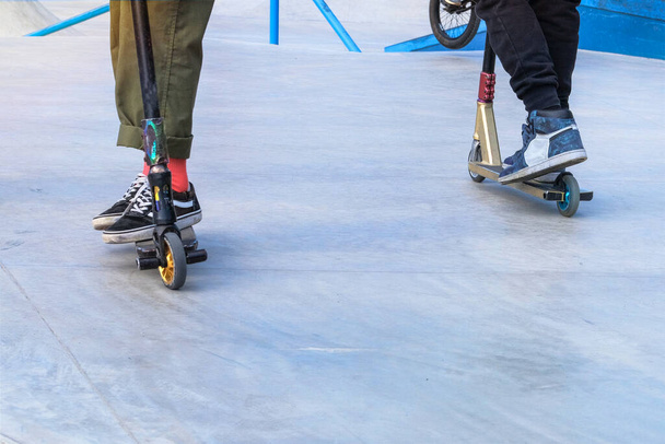Skater-Jungs haben an einem Sommertag Spaß beim Üben im Outdoor-Skatepark. Aktives Stadtleben. Urbane Subkultur. Kopierraum. - Foto, Bild