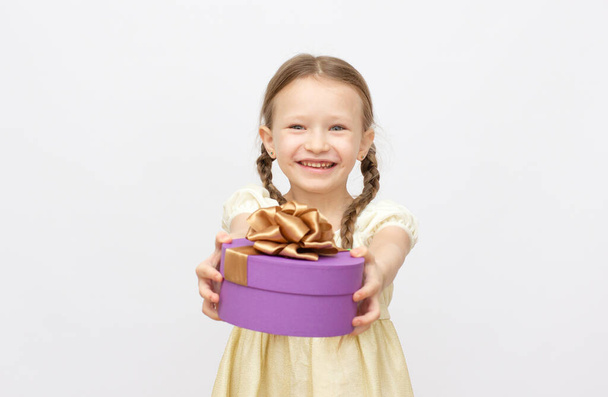 Adorable little surprise girl with purple gift box present on background - Foto, afbeelding