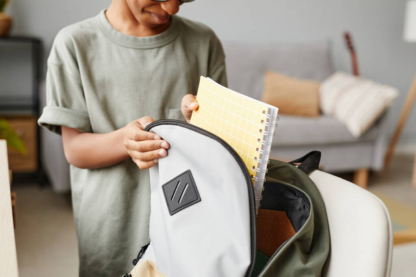 Close up of young African-American boy packing backpack at home, copy space - Φωτογραφία, εικόνα