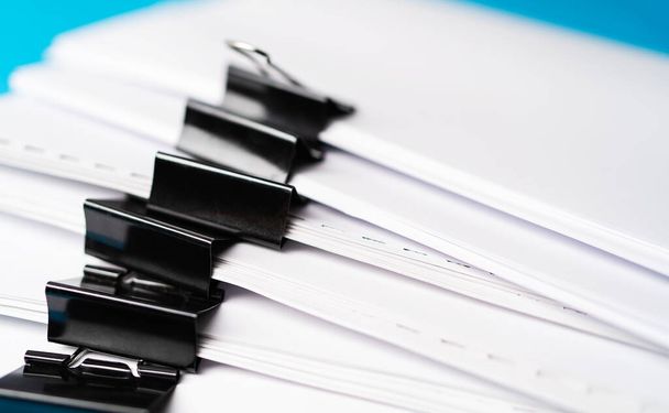 close-up stacking report paper office working paper, blue color background - Fotó, kép