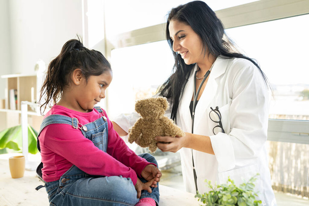 medico femminile dà orsacchiotto ai bambini - Foto, immagini