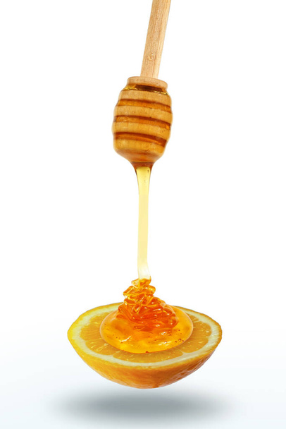 Miel goteando tarro de miel de madera en la rodaja de limón - Foto, imagen