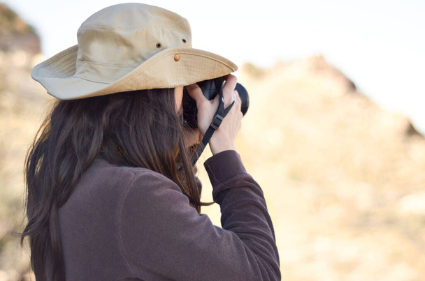 Capturando lo salvaje. Una joven mujer tomando fotos afuera. - Foto, Imagen