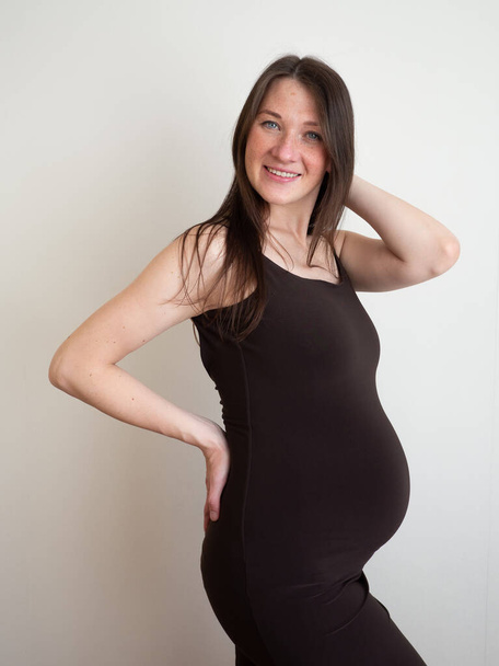 Portrait of beautiful and sexy pregnant young woman in dress. vertical. - Фото, изображение