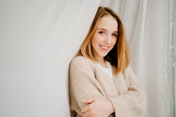 an attractive young woman in a cozy sweater. natural beauty and cosmetics. - Photo, Image