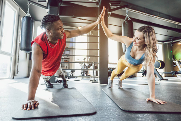 Fit man and woman in gym exercising abs - Photo, Image