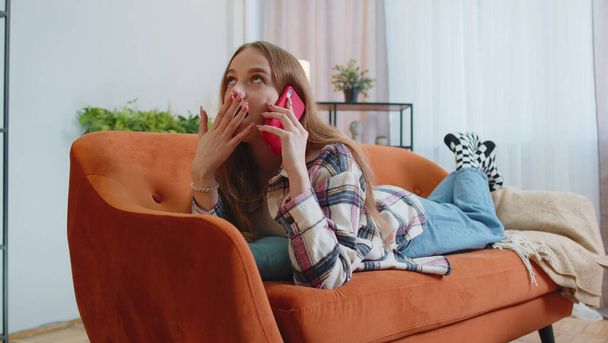 Portrait of tired sleepy woman talking on mobile phone with friend making online conversation home - Φωτογραφία, εικόνα