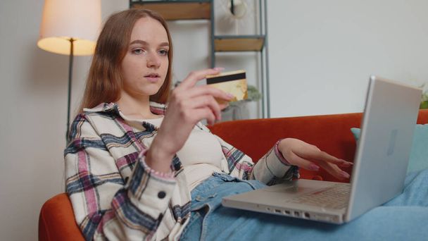 Nő ül otthon hitelkártyával és laptop PC-vel, miközben pénzt online vásárlás - Fotó, kép