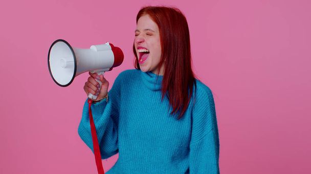 Mosolygó vörös hajú lány beszél megafonnal, híreket hirdet, hangosan hirdeti az eladó hirdetést - Fotó, kép