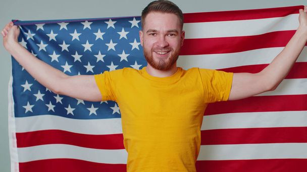 Mężczyzna machający, zawijający się w amerykańską flagę USA, świętujący, prawa człowieka, wolności, Dzień Niepodległości - Zdjęcie, obraz