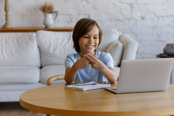 Boy looking at laptop showing sign language communicates with tutor - Foto, imagen