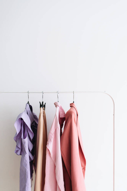 Capsule feminine cloth of pastel color don a rail. - 写真・画像