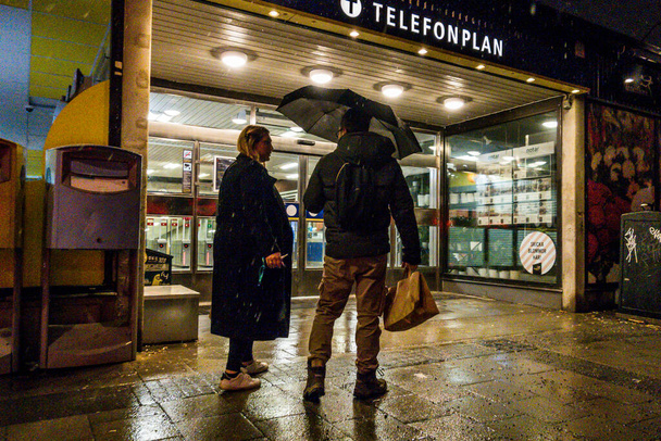 スウェーデンのストックホルムテレフォンプラントンネルバナや地下鉄の駅の入り口で雨の中でお別れを言うカップル. - 写真・画像