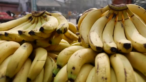 Банки спелых бананов на уличном рынке. Продажа желтых бананов на фруктовом рынке. Азиатский рынок. - Кадры, видео