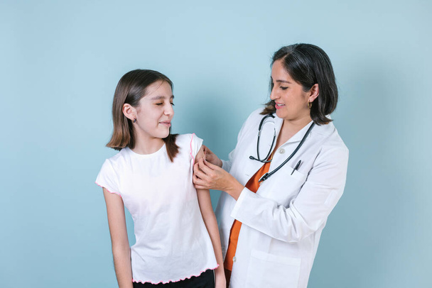 doctora inyectando vacuna a una linda niña hispana en México América Latina - Foto, Imagen