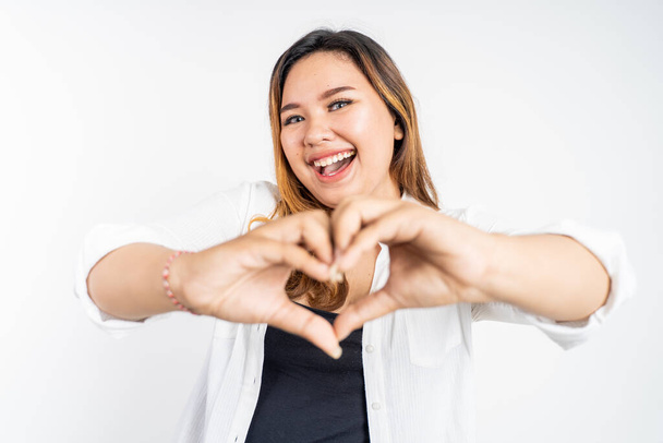 young woman laughing with heart shape with fingers - Фото, изображение