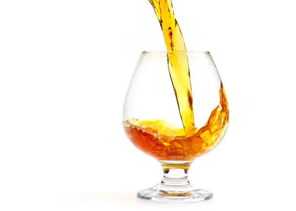 a strong alcoholic drink is poured into a glass - Zdjęcie, obraz