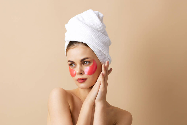 bella donna con un asciugamano sulla testa gesticolando con le mani la cura della pelle sfondo isolato - Foto, immagini