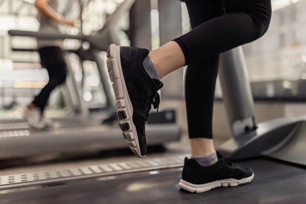 exercise concept The two treadmills being run by the two players that one wearing black sneakers while another one putting on white sneakers. - 写真・画像