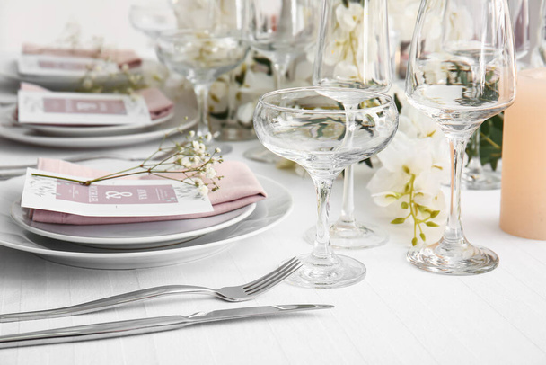 Cadre de table élégant avec des invitations de mariage et des fleurs de gypsophile - Photo, image