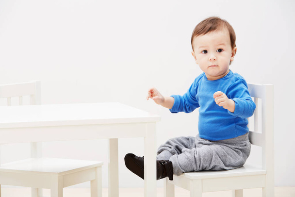 Im ready for dinner. Portrait of a cute baby boy sitting on a chair at a table. - Foto, Bild