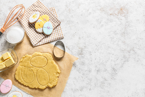 Čerstvé těsto a chutné velikonoční sušenky na světlém pozadí - Fotografie, Obrázek