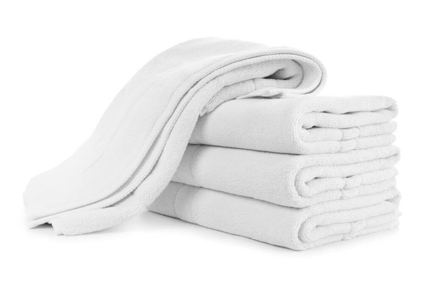 Empilement de serviettes pliées en coton blanc avec une chute sur le dessus - Photo, image