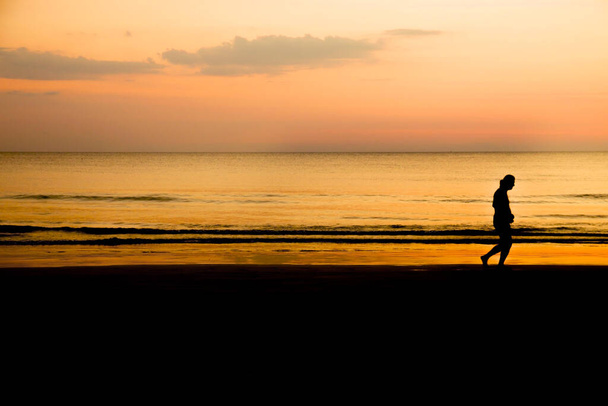 silhouette of a man jogging on the beach at sunset, healthy lifestyle - Foto, Bild