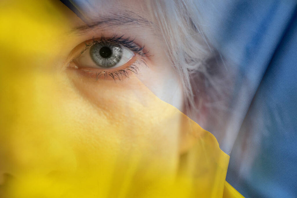 Gelb-blaue Nationalflagge der Ukraine und das Gesicht eines Mädchens, Stoppt den Krieg und den Frieden in der Ukraine, Freiheit für die Ukraine, Stoppt den Krieg - Foto, Bild
