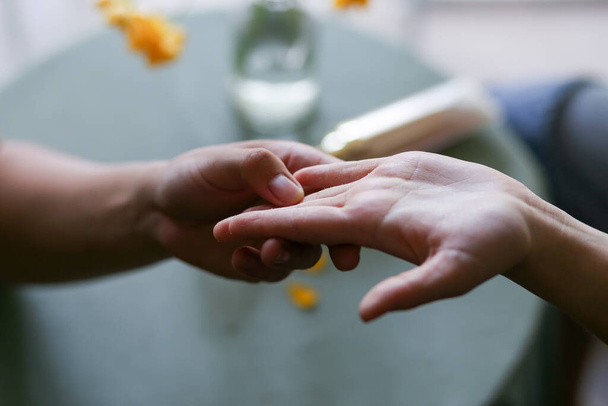 избирательный фокус руки молодой женщины рука мужчины держа руки женские руки в кофейной коже концепции мягкой женской руки - Фото, изображение