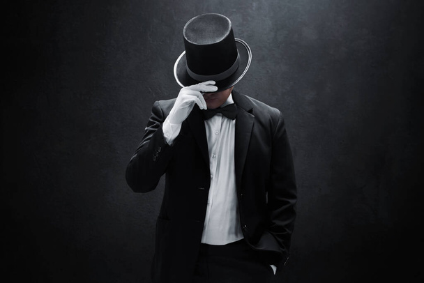 Mysterious man in black suit on dark background - Foto, imagen