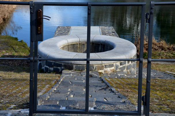 池のスライス規制とコンクリートダムのシャフトを備えた貯水池。ダムの下に流出する流れを決定するプロファイル。円の形をしたサービスストーンシャフトがよく届く - 写真・画像