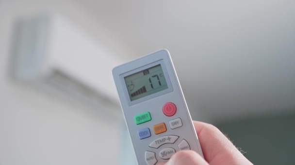 Hand adjusting temperature on air conditioner with remote control, Working air conditioner for comfort temperature in home at hot summer - Felvétel, videó