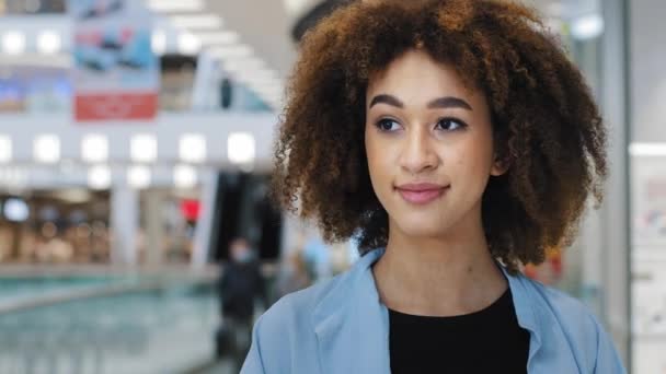 Retrato chica relajada afroamericana mujer de 20 años con el pelo rizado elegante peinado mujer de negocios gerente beber té de café de la taza de papel desechable disfrutando del fin de semana de descanso de trabajo en el centro comercial - Metraje, vídeo