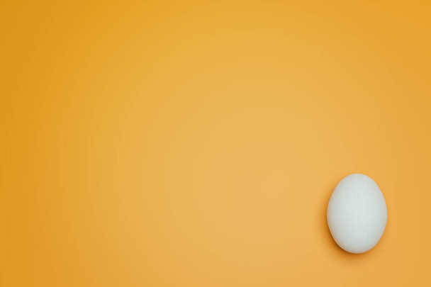 Одне біле куряче яйце на жовтому тлі зверху. Креативна їжа мінімалістичний фон
. - Фото, зображення