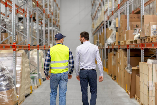 worker and businessman walking along warehouse - Foto, Bild