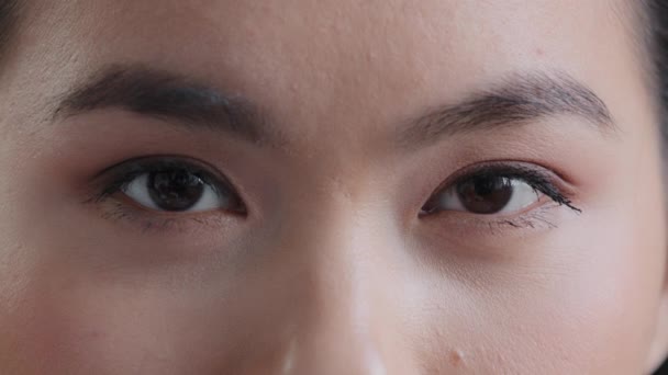 Nainen tumma musta kirkkaat silmät nuori aasialainen korealainen tyttö katselee kameraa nainen, jolla on hyvä näkö näkökyky pitkät silmäripset luonnollinen meikki katso onnistuneen laserleikkaus silmätautien - Materiaali, video
