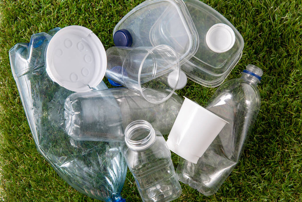 close up of empty used plastic bottles on grass - Zdjęcie, obraz